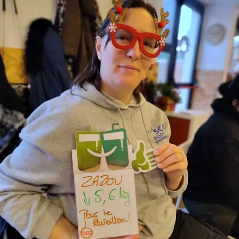 Ardoise levée et grand sourire, une membre montre son bilan