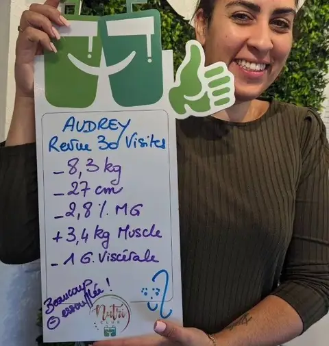 Ardoise levée et grand sourire, une membre montre son bilan