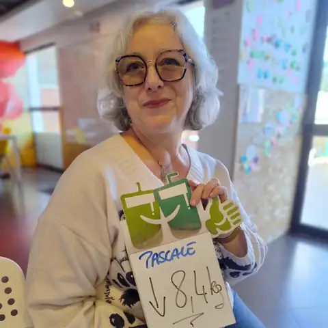 Le bilan figure sur une ardoise blanche que présente une membre, dans la salle du club