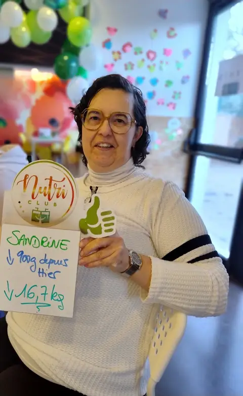 Ardoise levée et grand sourire, une membre montre son bilan